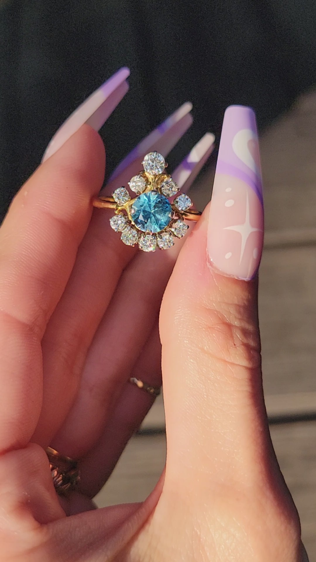 Pictures do not do this princess justice. This stunner is crafted in 18kt yellow gold and she is truly exquisite. The way the diamonds capture the light will surely cast rainbows all around you. The large blue topaz center stone is light and beautiful, but frequently photographs darker than eye sees. We know you will feel like royalty rocking this princess, so we aptly named her the Tiara.