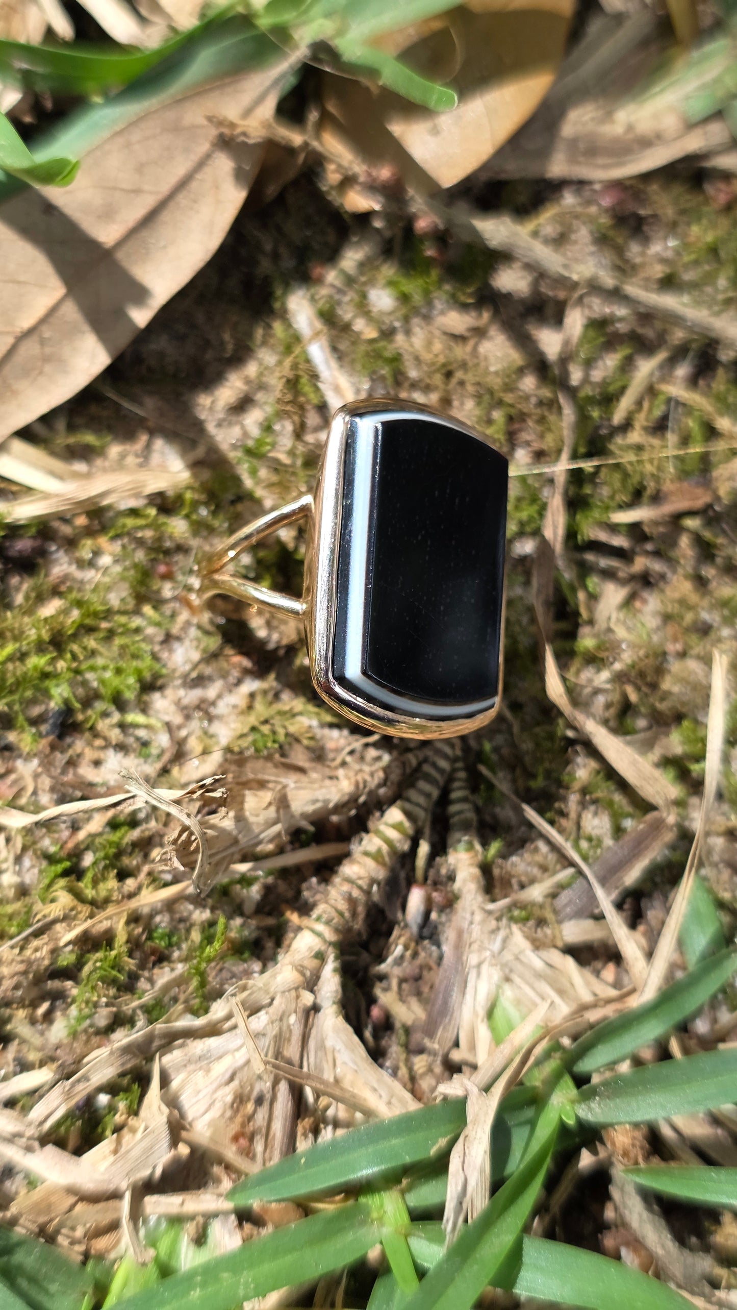 Small black rectangular agate ring on a natural background
