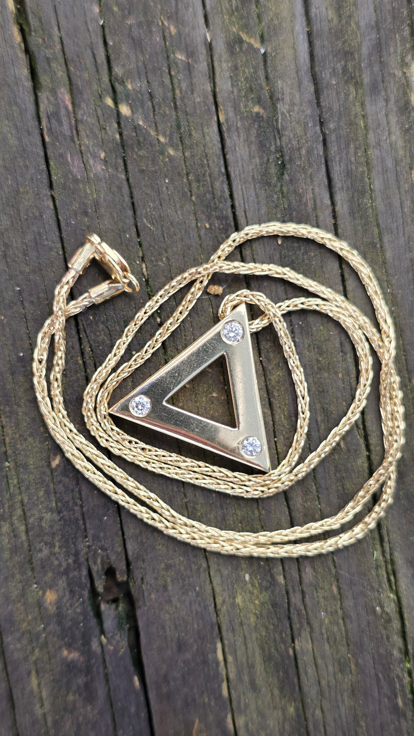 Necklace with a triangular pendant on a wooden surface