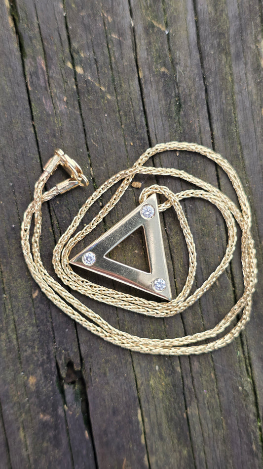 Necklace with a triangular pendant on a wooden surface