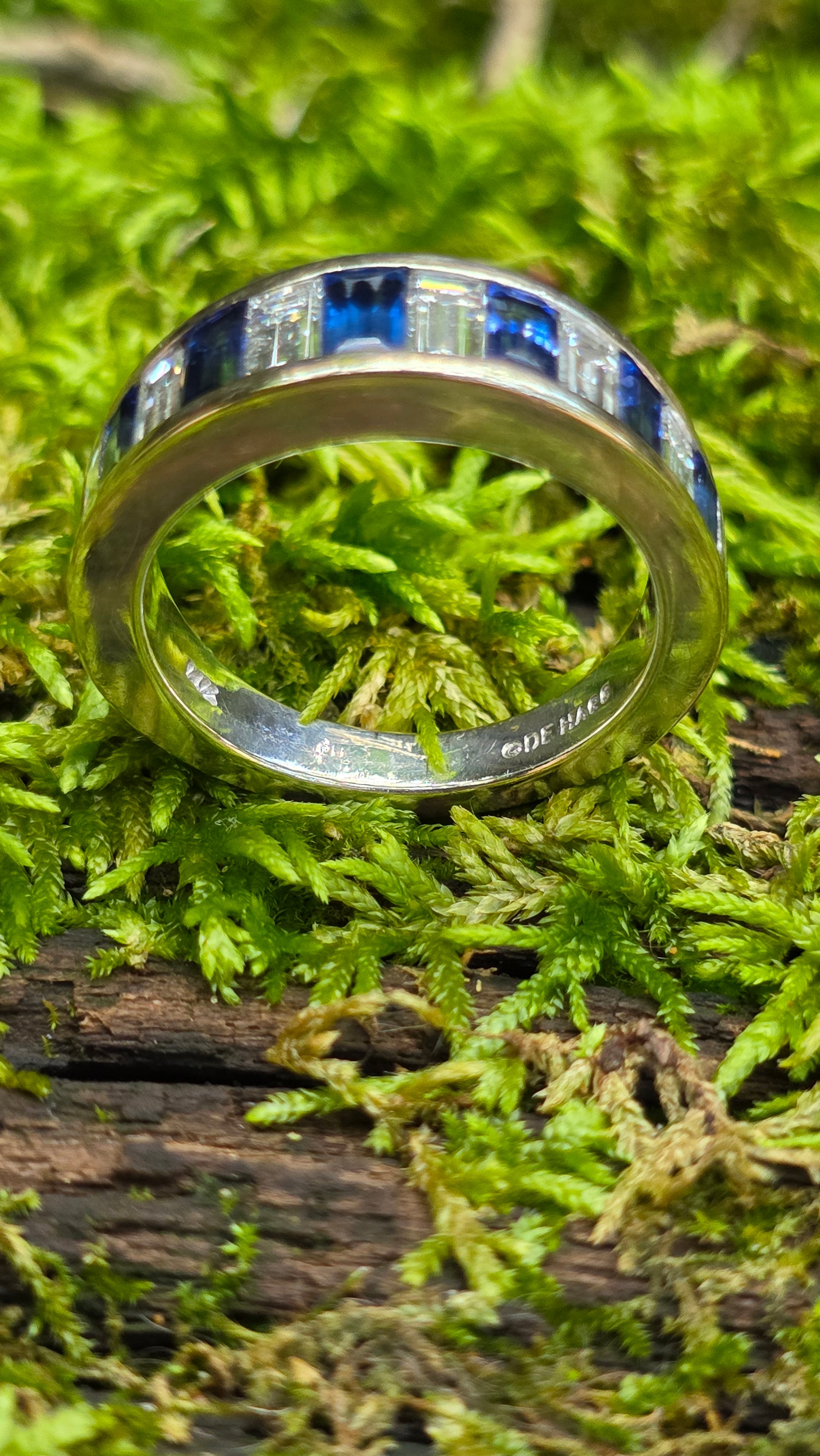 White Gold ring with blue accents on a mossy surface