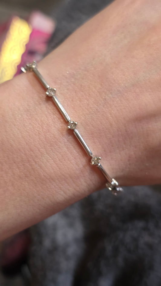 White gold and diamond bracelet on a wrist with a blurred background