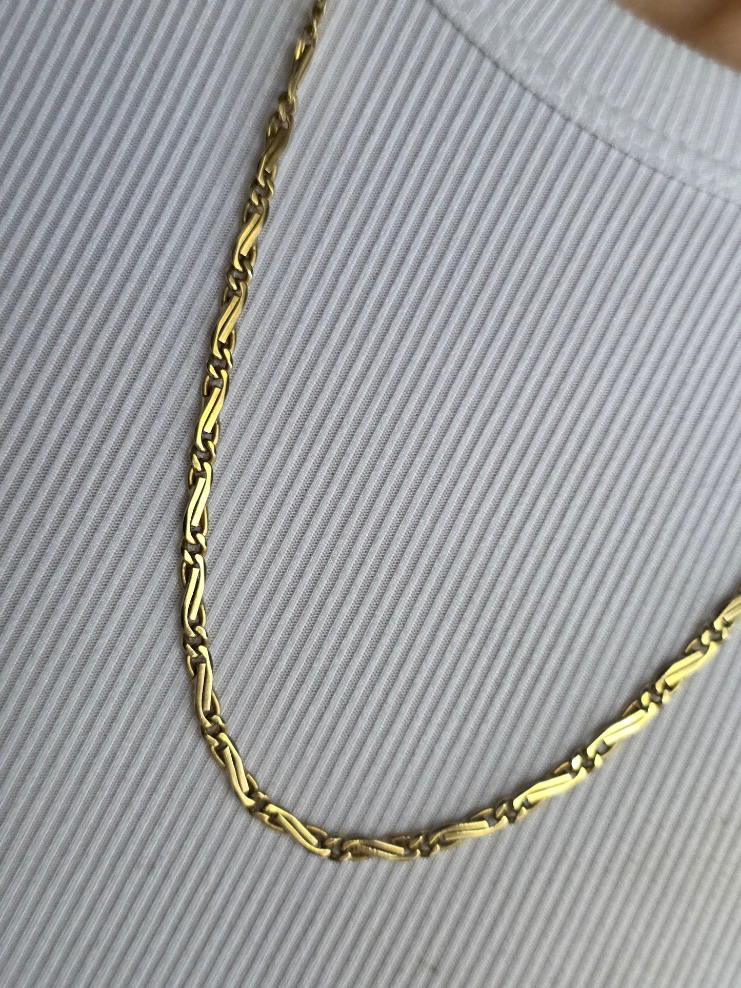 Gold chain on a textured gray background