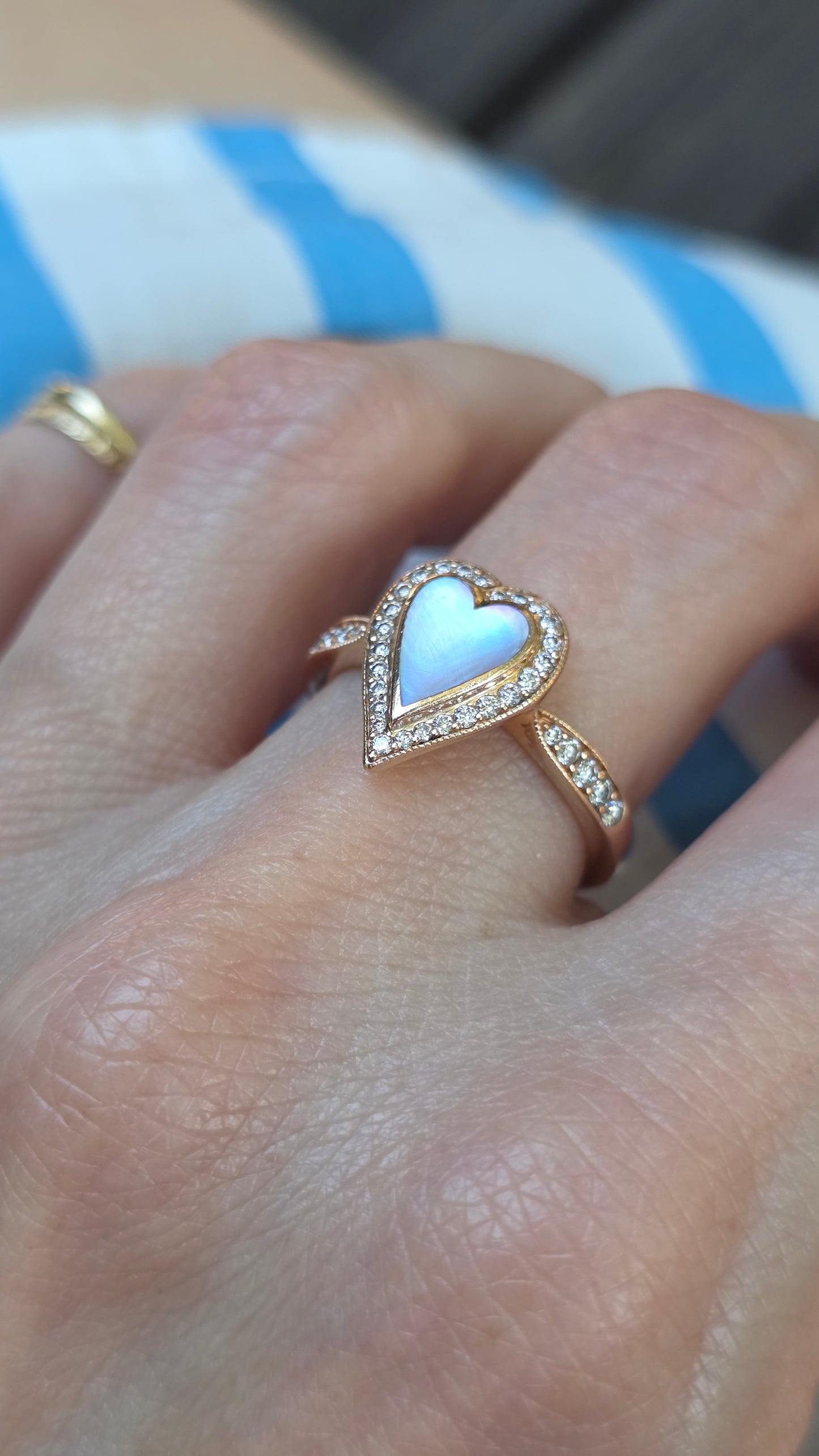 Heart-shaped ring on a person's finger with a blurred background