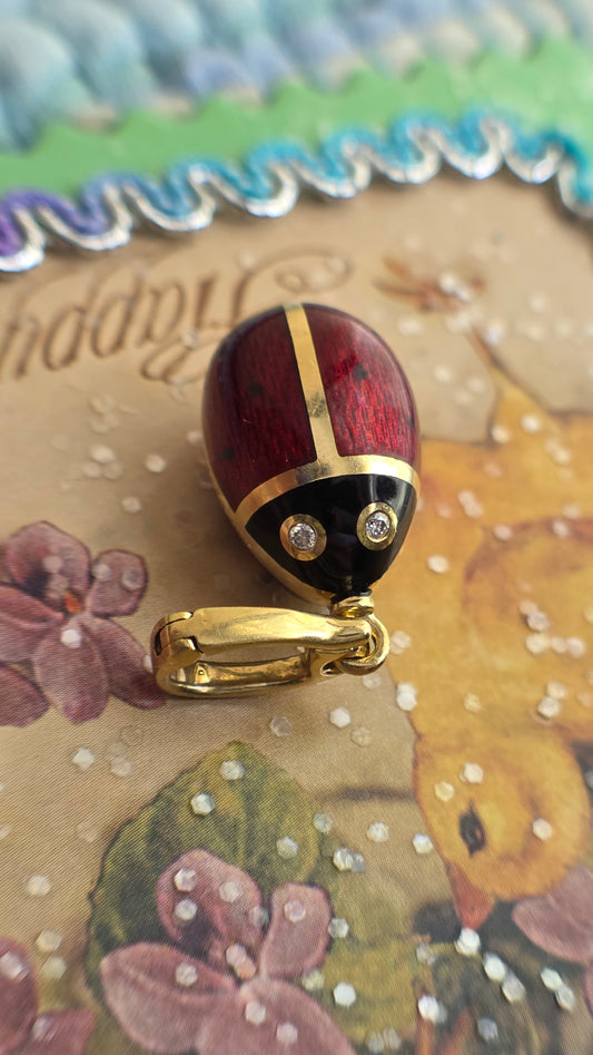 Decorative easter egg charm with gold accents on a floral card background