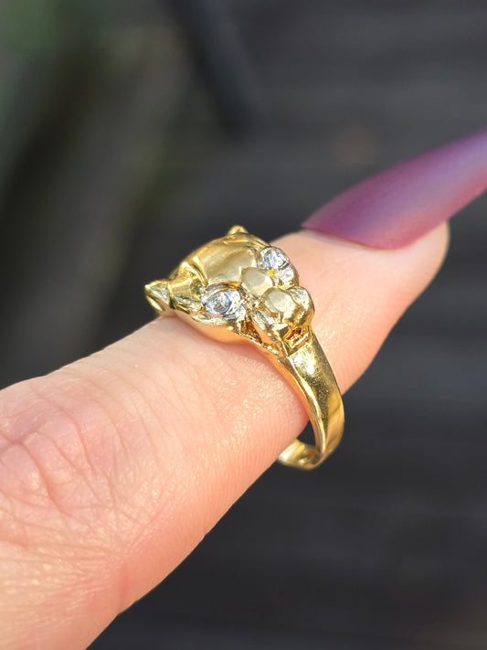 Gold ring with diamonds on a finger against a blurred background