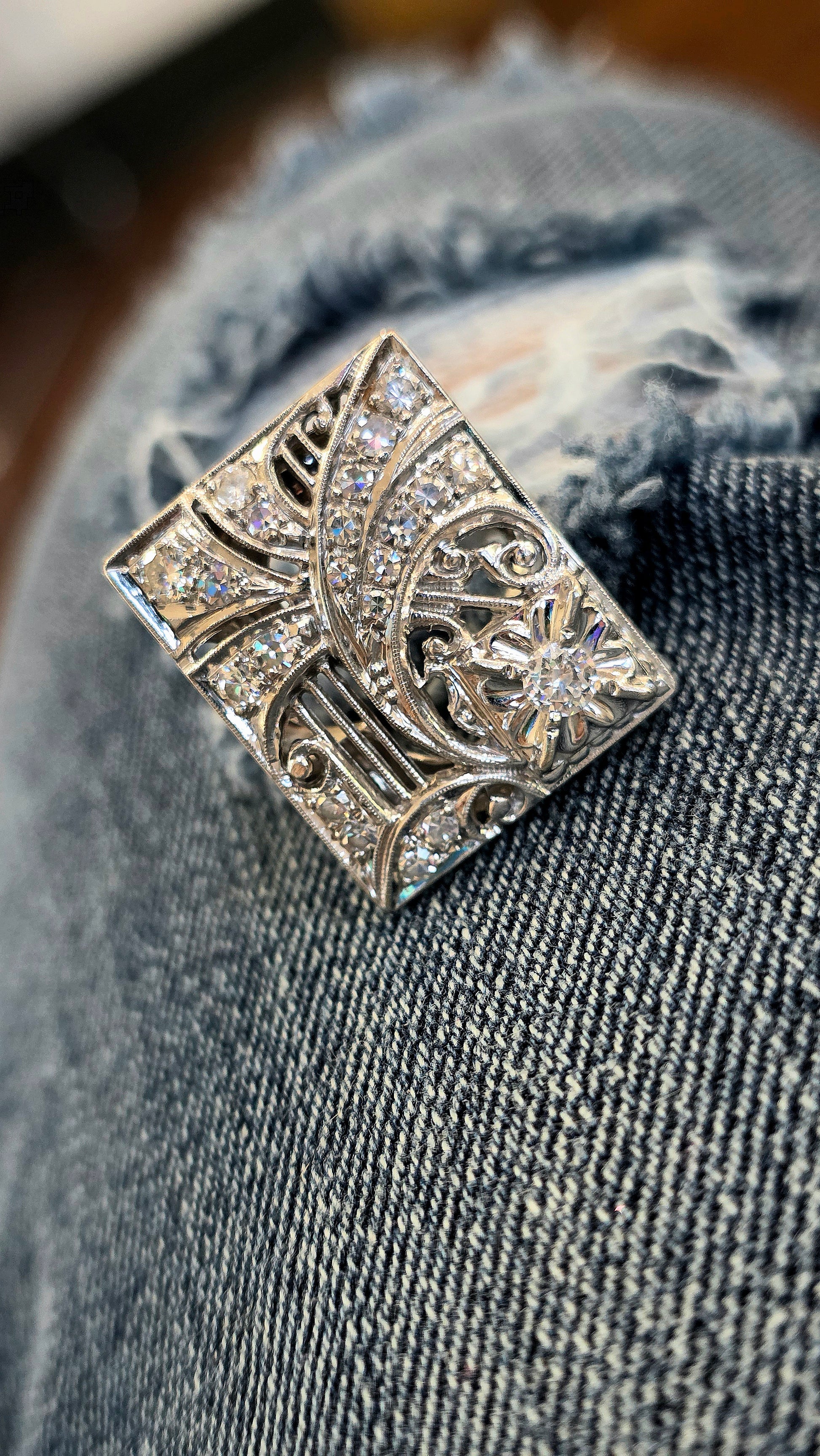 Decorative white gold and diamond ring on a denim jacket