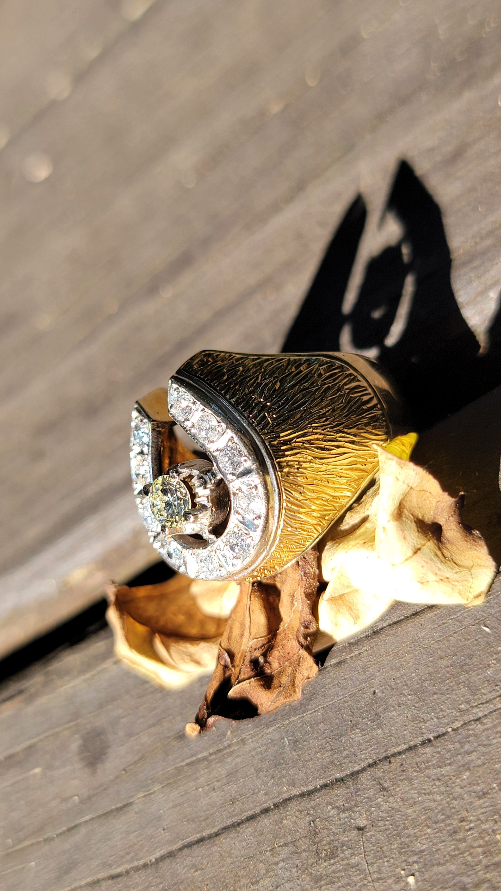Gold ring with a diamond on a wooden surface
